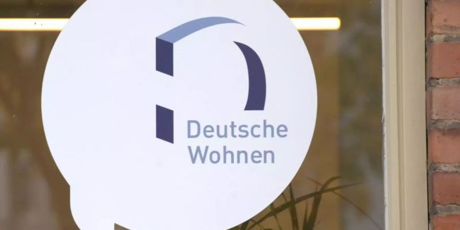 Das Logo des Immobilien-Anbieters Deutsche Wohnen klebt auf der Scheibe des Servicepoints des Unternehmens in Berlin-Britz. Foto: Paul Zinken