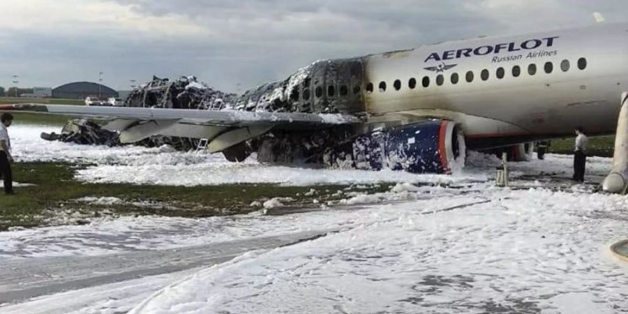 Etwa zur Hälfte verkohlt: Die weitgehend ausgebrannte Suchoi Superjet-100 auf dem Flughafen in Moskau. Foto: Moscow News Agency/AP