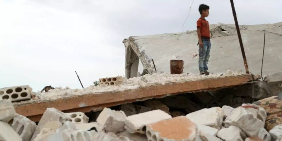 Ein Junge in den Trümmern eines Hauses im Dorf Rabaa Dschur in Idlib
