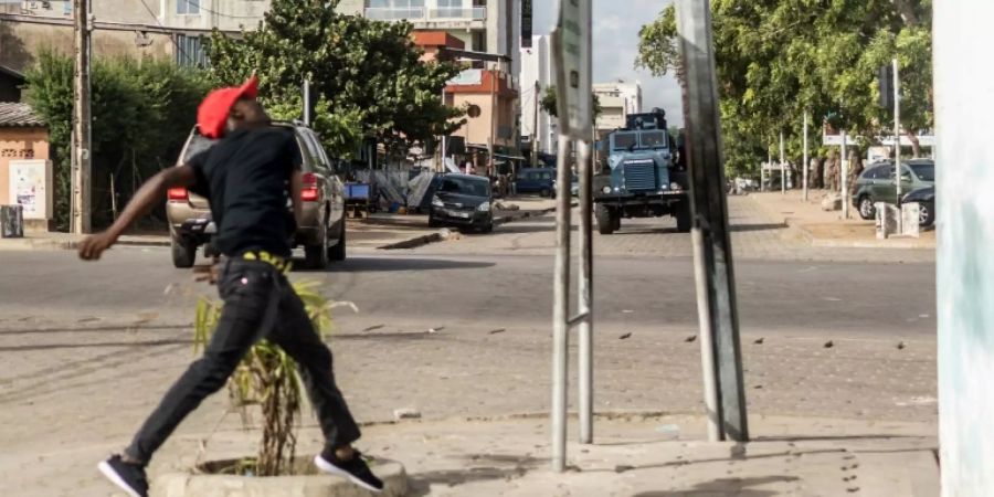 Steinewerfer und gepanzertes Polizeifahrzeug in Cotonou