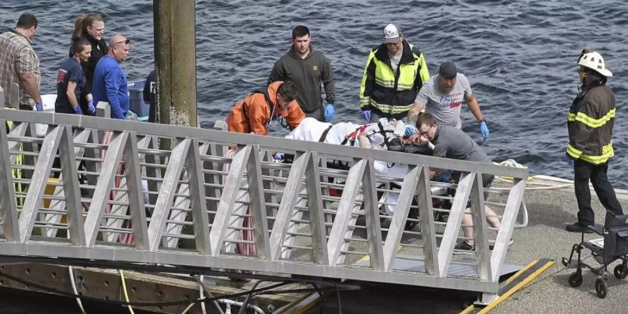 Rettungskräfte transportieren einen verletzten Passagier zu einem Krankenwagen in den Docks des George Inlet vor der Küste von Alaska. Foto: Dustin Safranek/Ketchikan Daily News