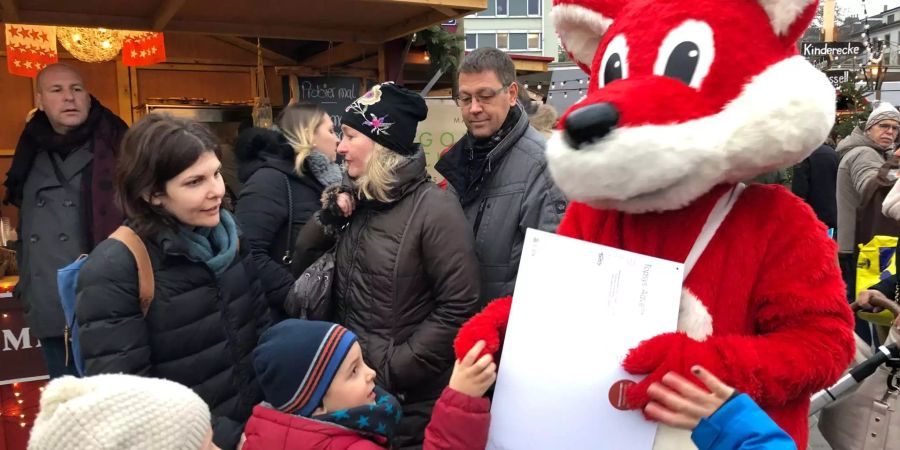 Beim Weihnachtsmarkt auf dem Sechseläutenplatz verteilt Topsy Adventskalender an Kinder.