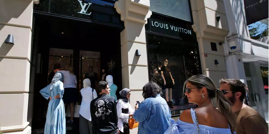 Junge Leute vor einem Louis-Vuitton-Geschäft.