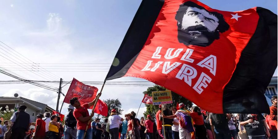 Ein Anhänger von Ex-Präsident Lula da Silva hält eine Flagge mit der Aufschrift: «Lula frei» vor dem Hauptquartier der Polizei.