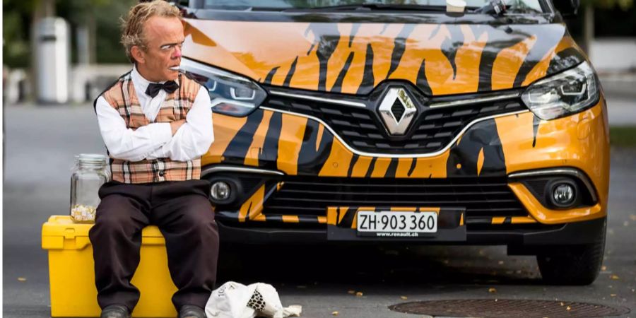 Clown Spidi posiert vor einem Auto.