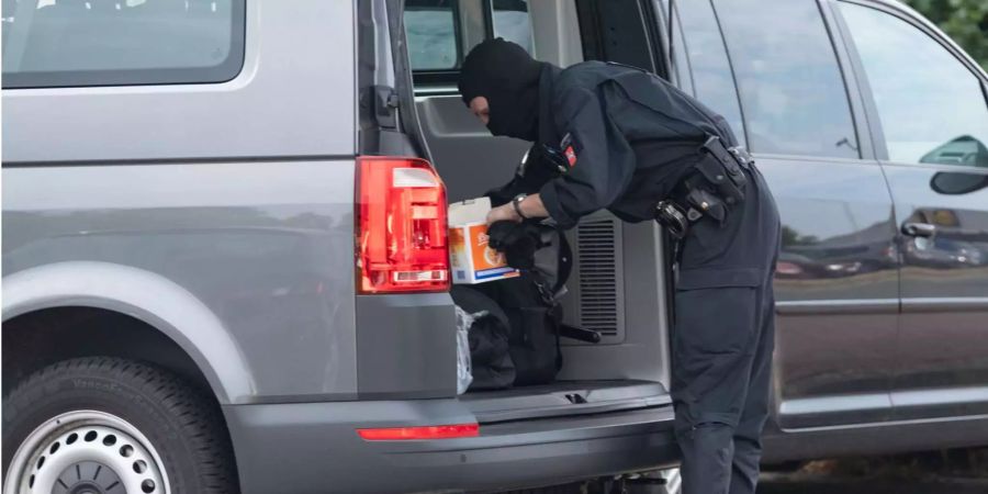 Ein Polizeibeamter ist an einem Fahrzeug in Nienburg (D) zu sehen.