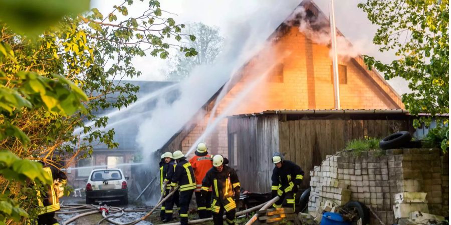 Einsatzkräfte der Feuerwehr löschen einen Hausbrand. Ein fünfjähriges Mädchen ist bei einem Hausbrand ums Leben gekommen.