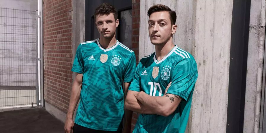 Thomas Müller und Mesut Özil posieren im neuen grünen Auswärtsdress Deutschlands.