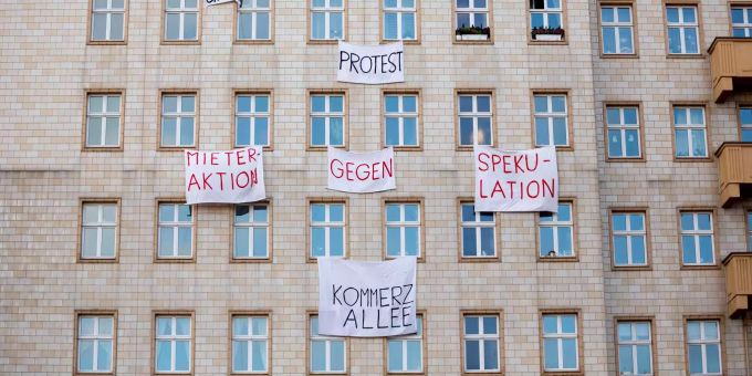 Plakate gegen den Verkauf von Mietwohnungen an die Deutsche Wohnen SE hängen an einer Gebäudefassade in der Karl-Marx-Allee. Plakate gegen den Verkauf von Mietwohnungen an die Deutsche Wohnen SE hängen an einer Gebäudefassade in der Karl-Marx-Allee.