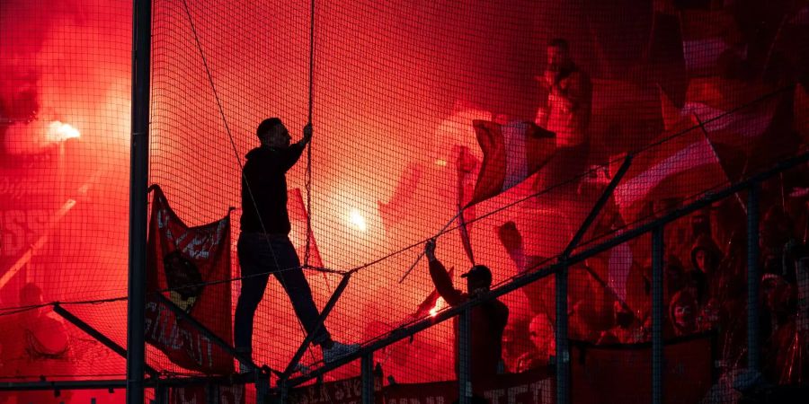 Bengalos brennen vor einer Fussball-Partie.