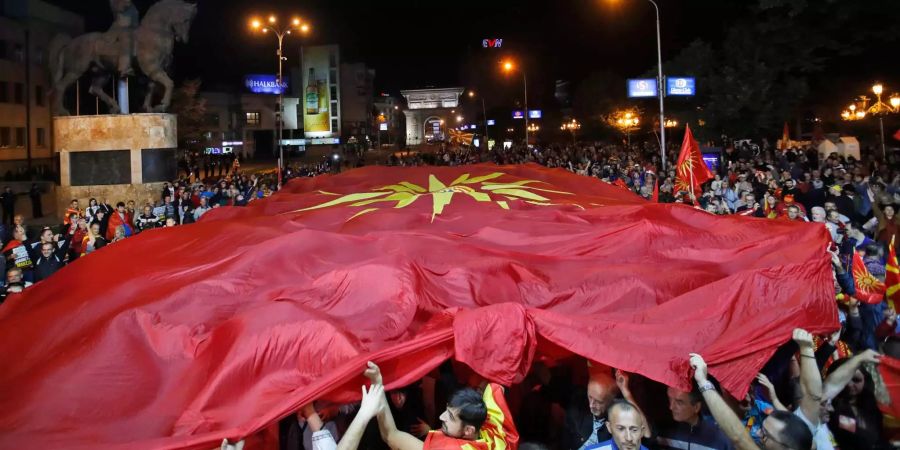 Unterstützer einer Bewegung für Wähler, die das Referendum boykottieren, halten eine riesige mazedonische Flagge, nach der Verkündung der Ergebnisse.