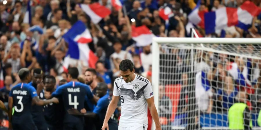 Mats Hummels aus Deutschland reagiert nach dem Elfmeter von Antoine Griezmann (nicht im Bild) aus Frankreich zum 2:1-Endstand, während die Franzosen im Hintergrund jubeln.