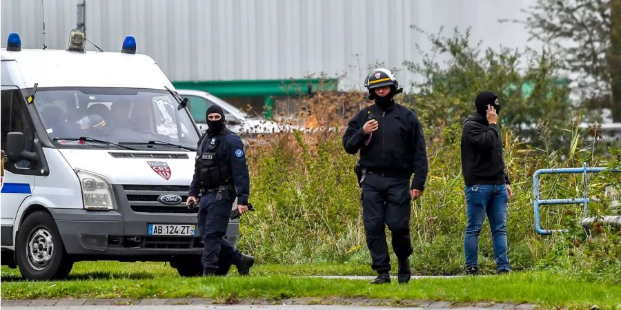 Vermummte Polizisten stehen während einer Suchaktion in Grande-Synthe bei Dünkirchen (FR) vor dem Hauptsitz des Centre Zahra.