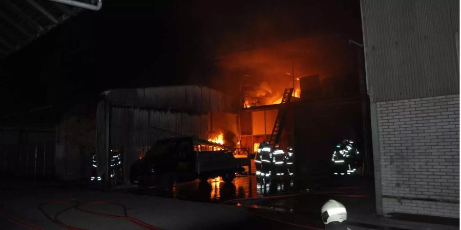 Feuerwehrleute schreiten zur brennenden Lagerhalle in Solothurn.