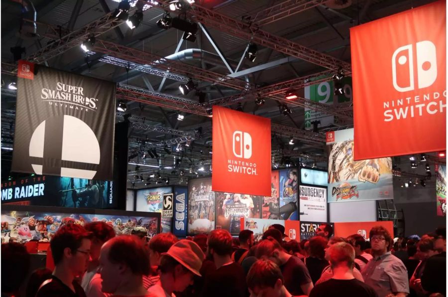 Der Nintendo Stand an der Gamescom 2018. Die Nintendo Switch und Super Smash Bros. Ultimate Flaggen über dem Stand sind zu sehen.