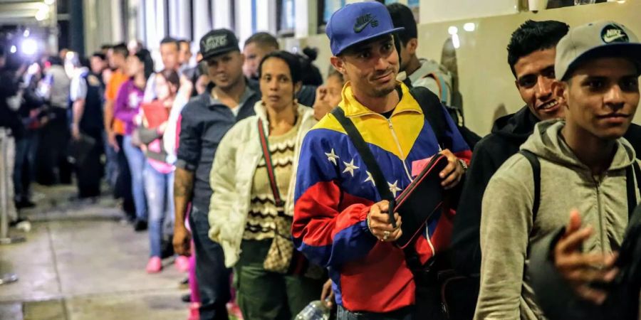 Venezolanische Migranten stehen in einer Warteschlange an der peruanischen Grenze.