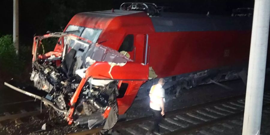 Fahrzeugteile eines Lastwagens liegen auf den Schienen vor einem IC.