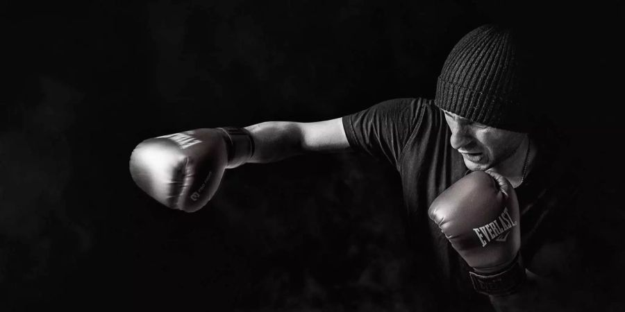 Ein Kickboxer boxt vor schwarzem Hintergrund mit der rechten Faust. Bei den Prüglern handelte es sich um Kickboxer. (Symbolbild)