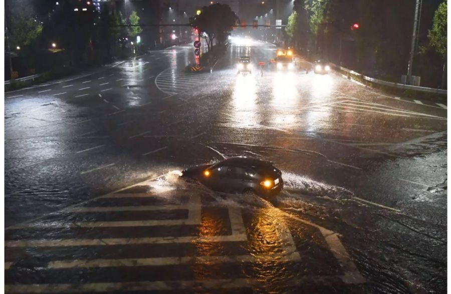 Ein Fahrzeug fährt über eine durch Taifun «Lan» überflutete Strasse in Nagoya (Japan).