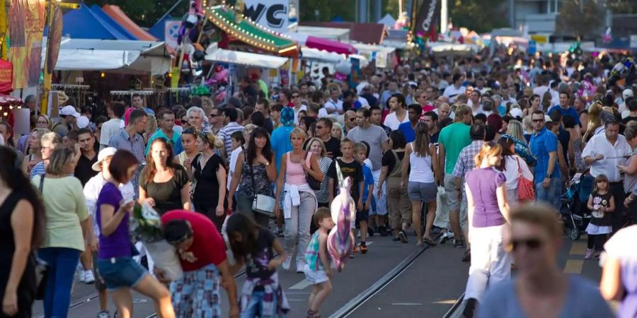 Menschen flanieren über das Gelände des Knabenschiessens.