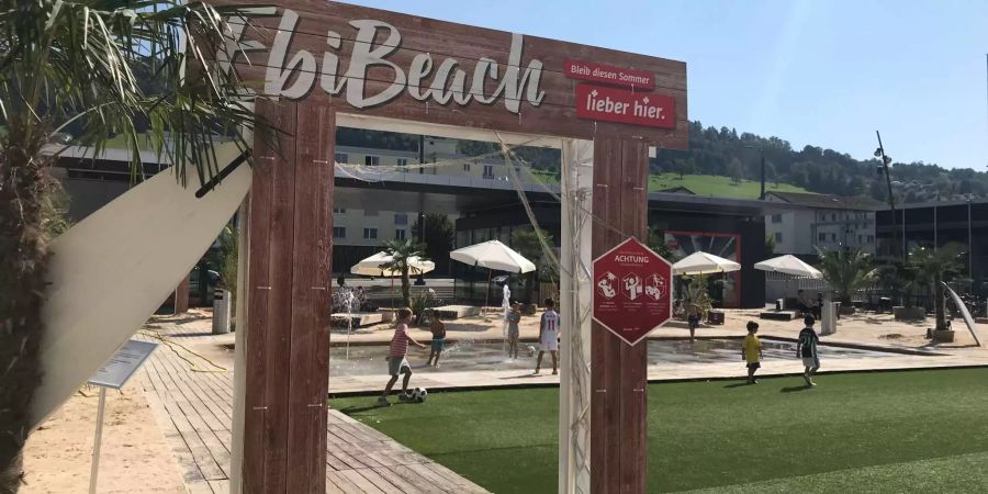 Vor der Mall of Switzerland steht der «Ebi Beach» mit Sand, Palmen und Liegestühlen.