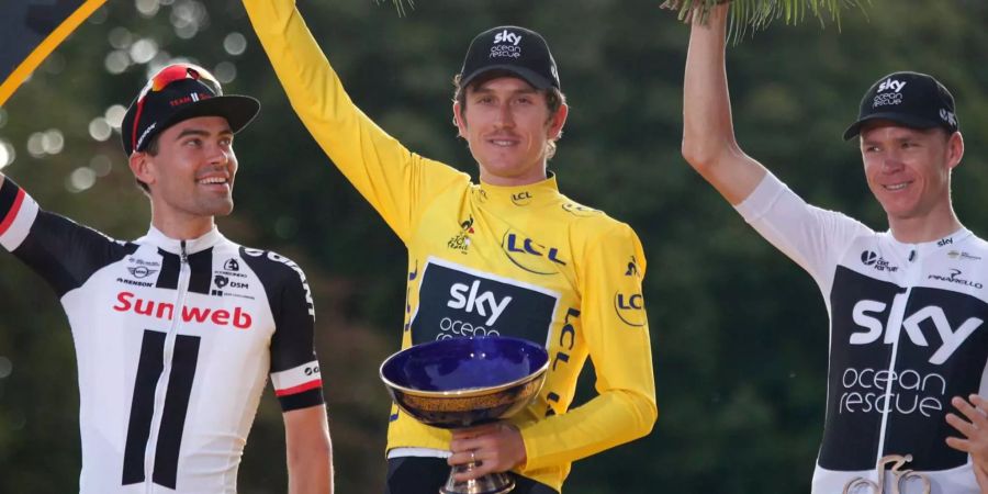 Geraint Thomas (M) feiert seinen Pokal der Tour de France.