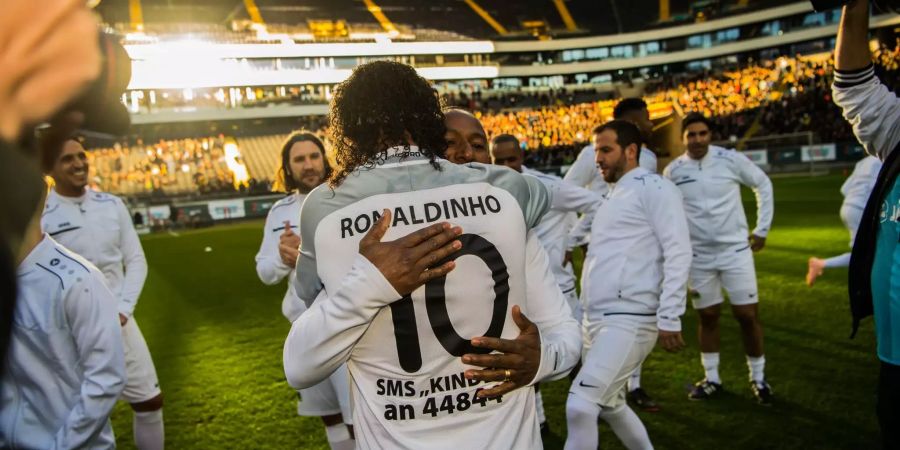 Ronaldinho, ehemaliger brasilianischer Fussballprofi, umarmt Ailton, ehemaliger Fussballprofi von Werder Bremen, in der Commerzbank-Arena in Frankfurt.