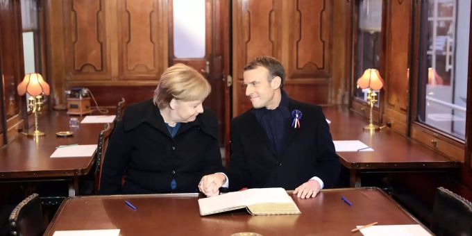 Die deutsche Bundeskanzlerin Angela Merkel (l.) und Frankreichs Präsident Emmanuel (r.) tragen sich in das Goldene Buch des Museums der Gedenkstätte bei Compiègne (F) ein, in dem dort ausgestellten Eisenbahnwagen. (Archivbild) Angela Merkel Präsident Emmanuel