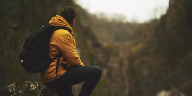 Ein Backpacker sitzt auf einem Felsen. (Symbolbild)