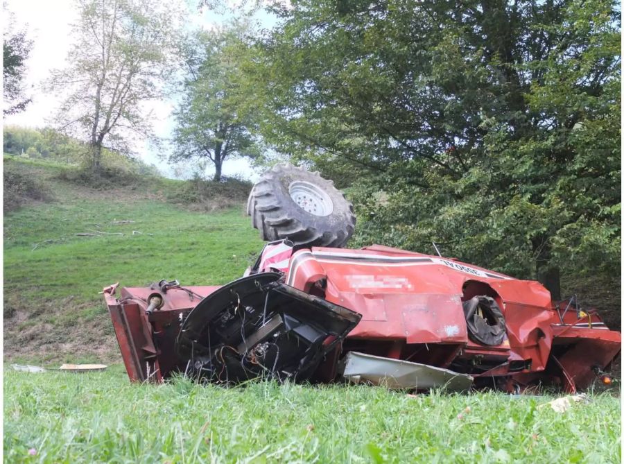 Umgekippter roter Mähdrescher auf einer Wiese - Keystone