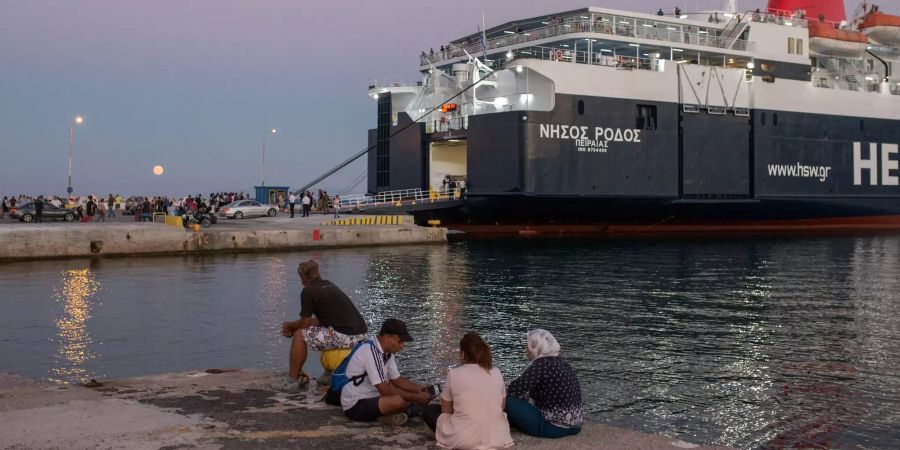 Flüchtlinge sitzen im Hafen von Mitilini in Griechenland.