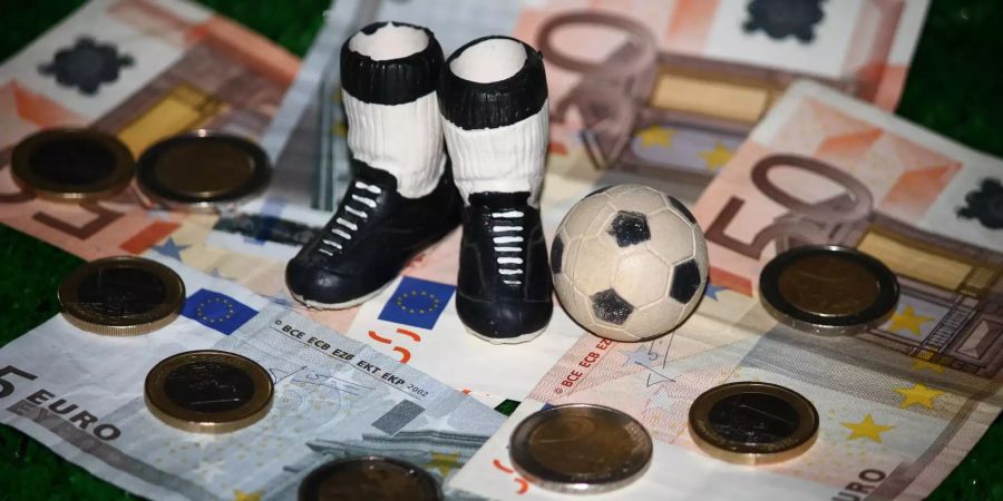 Euro-Münzen und Geldscheine liegen auf einem Tisch.