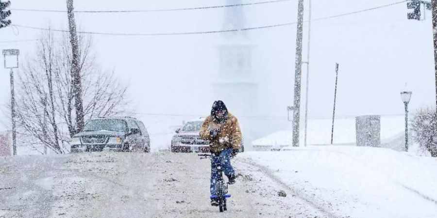 Ein Radfahrer fährt durch das winterliche Hagerstown im Mittleren Westen der USA. Foto: By Colleen Mcgrath/The Herald-Mail/AP