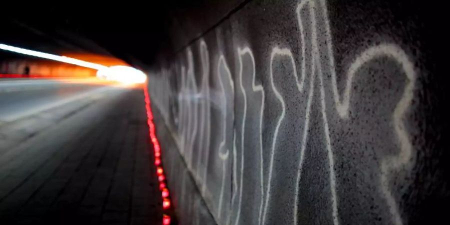 Kerzen zum Gedenken an die Opfer stehen aufgereiht im Tunnel zum ehemaligen Loveparade-Gelände. Foto: Oliver Berg