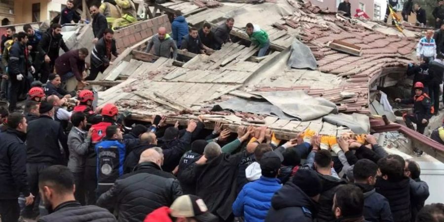 Rettungskräfte suchen in den Trümmern des siebenstöckigen Gebäudes nach Überlebenden. Zwölf der Verschütteten konnten gerettet werden. Foto: DHA