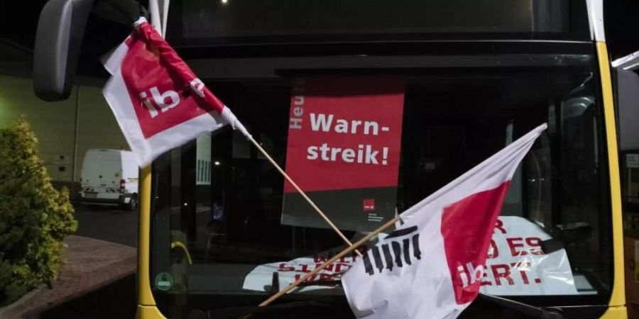 «Warnstreik» steht auf dem Plakat an einem Bus, der in der Zufahrt zum Betriebshof der Berliner Verkehrsbetriebe (BVG) an der Siegfriedstrasse steht. Foto: Paul Zinken