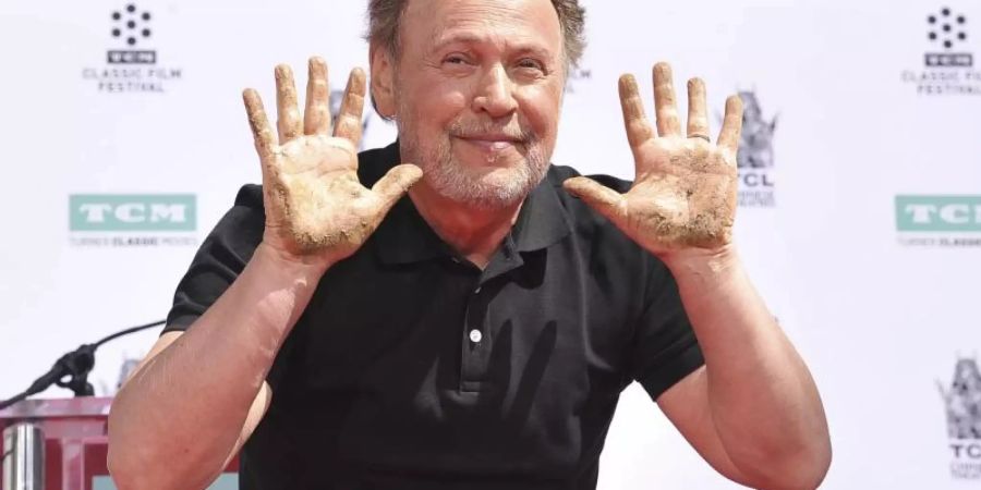 Der Schauspieler Billy Crystal (71) zeigt seine Hände, nachdem er sie während einer Hand- und Fussabdruckzeremonie vor dem TCL Chinese Theatre in der kalifornischen Filmmetropole in Zement gelegt hat. Foto: Richard Shotwell/Invision