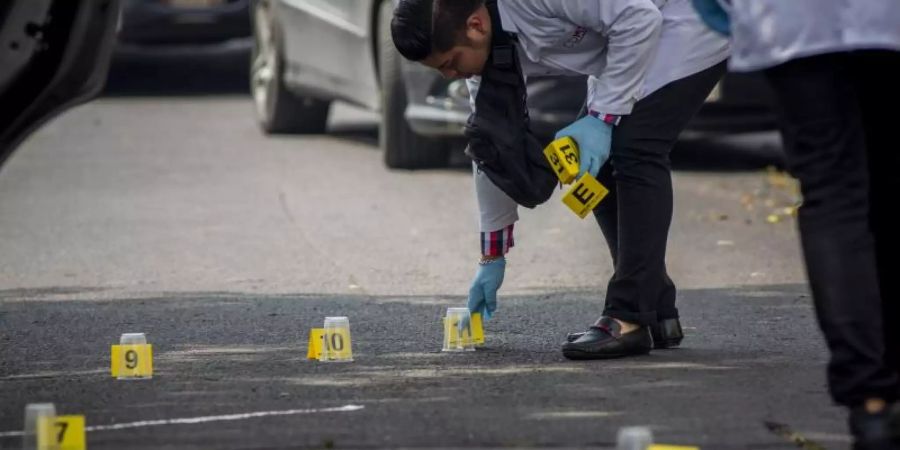 Ein forensischer Experte sammelt Beweise nach dem Tod von zwei Menschen nach einem Streit zwischen zwei kriminellen Organisationen im Norden von Mexiko-Stadt. Foto: Jair Cabrera Torres/dpa