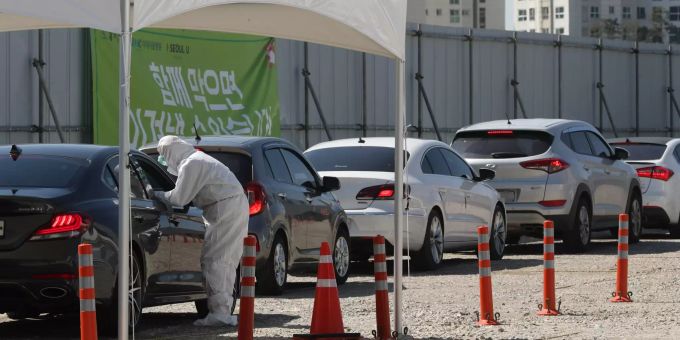 16.03.2020, Südkorea, Seoul: Personen in Autos warten in einer Schlange in einer Drive-Thru-Klinik, um sich einem Test auf das neuartige Coronavirus zu unterziehen. Coronavirus - Südkorea