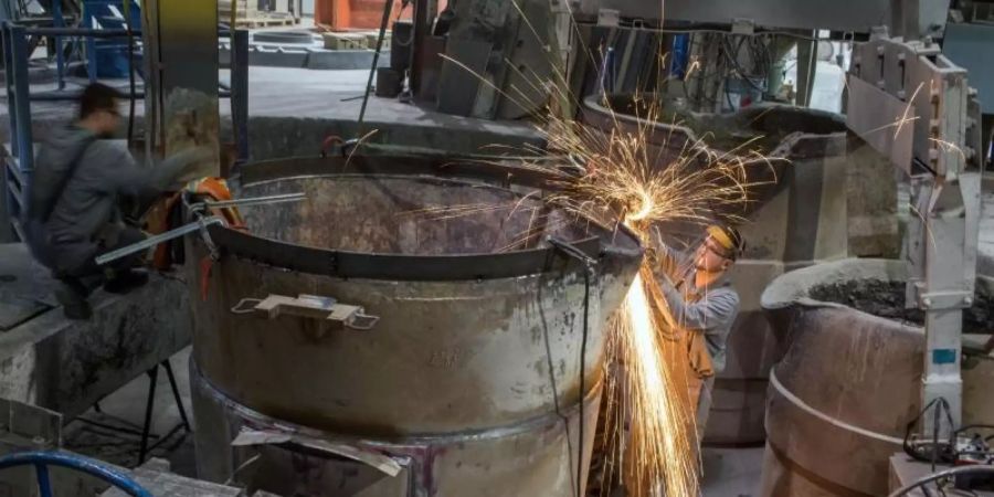 Mitarbeiter in einer Giesserei. Die Bundesregierung arbeitet bei Corona-Hilfen an Nachbesserungen für mittelständische Unternehmen, um eine Pleitewelle zu verhindern. Foto: Jens Büttner/dpa-Zentralbild/dpa