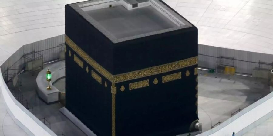 Arbeiter desinfizieren den Boden um die Kaaba, das quaderförmige Gebäude in der Grossen Moschee. Foto: Amr Nabil/AP/dpa