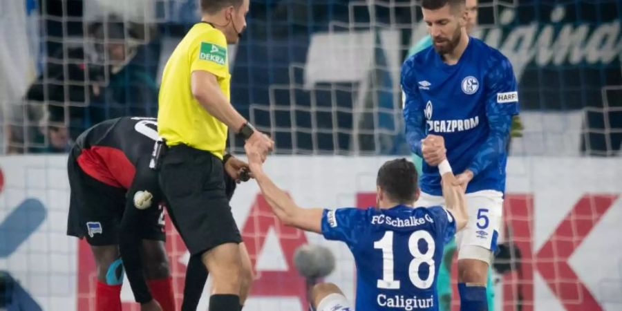 Daniel Caligiuri (M.) hatte sich im Pokalspiel gegen Hertha am Knie verletzt. Foto: Bernd Thissen/dpa