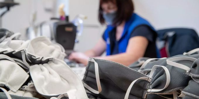 Eine Näherin näht Mundschutzmasken. Mundschutzmasken