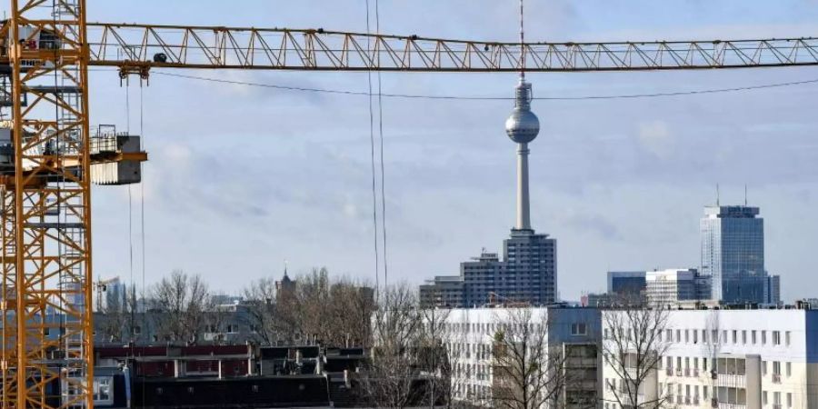 Der Fernsehturm am Alexanderplatz ist hinter Baukränen und Mietshäusern zu sehen. Als erstes Bundesland führt Berlin den Mietendeckel ein. Foto: Jens Kalaene/dpa-Zentralbild/dpa/Archiv