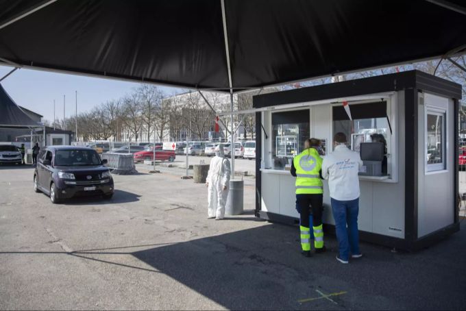 Ein Auto fährt zu Station 2, wo der Abstrich für den Test genommen wird. drive-in bern coronavirus