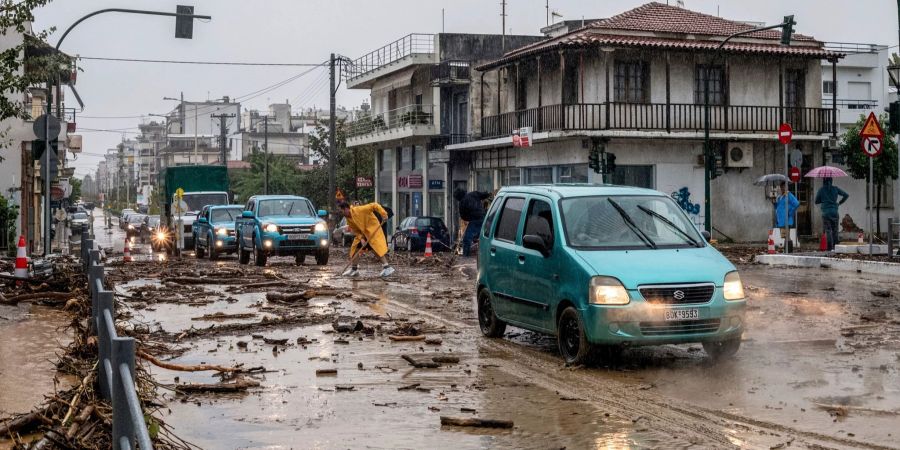 Ein Mann säubert die Strasse nach dem Hochwasser in Volos.