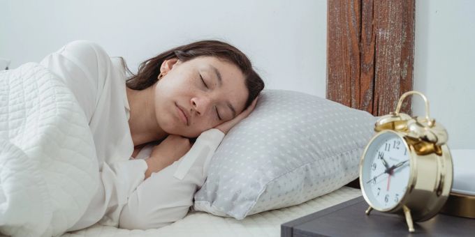 Zu einer festen Uhrzeit schlafen zu gehen, hat durchaus Vorteile. Schlaf, Einschlafen, Zeit, Frau