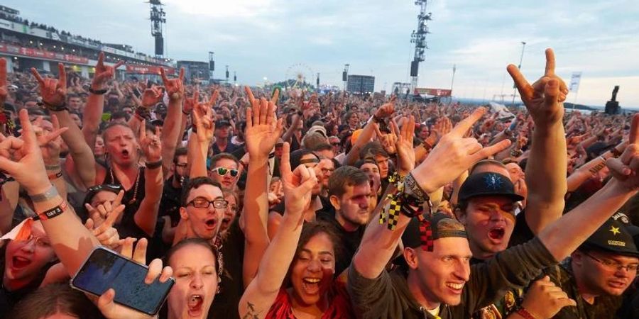 Musikfans jubeln auf dem Gelände des bislang letzten Festivals "Rock am Ring" 2019 in der Eifel. Foto: Thomas Frey/dpa