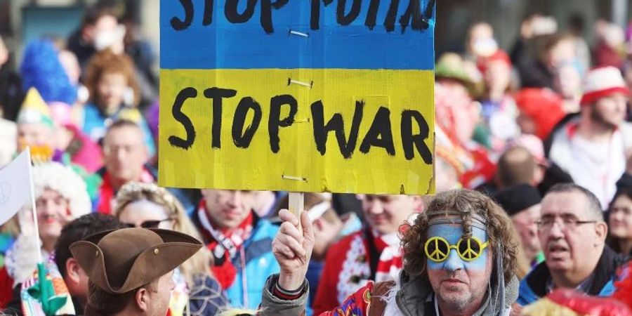 Protestplakat gegen den Krieg beim Kölner Strassenkarneval. Foto: Oliver Berg/dpa