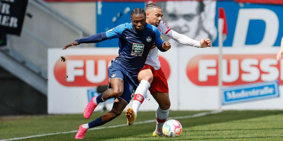 Der Kaiserslauterner Aaron Opoku (l) und der Regensburger Leon Guwara im Zweikampf um den Ball.
